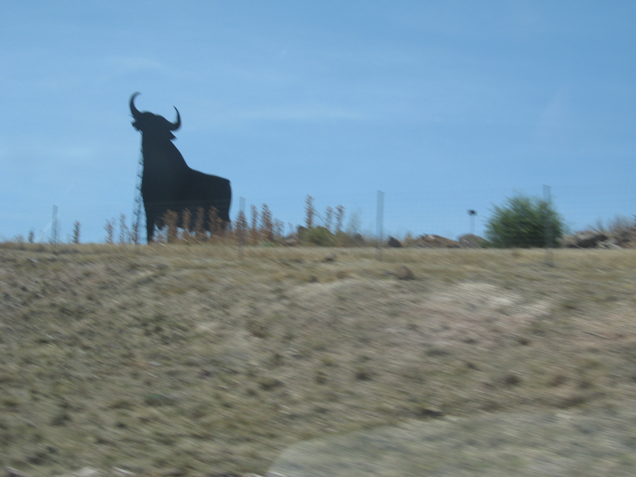 A Spanish bull sculpture against a blue sky